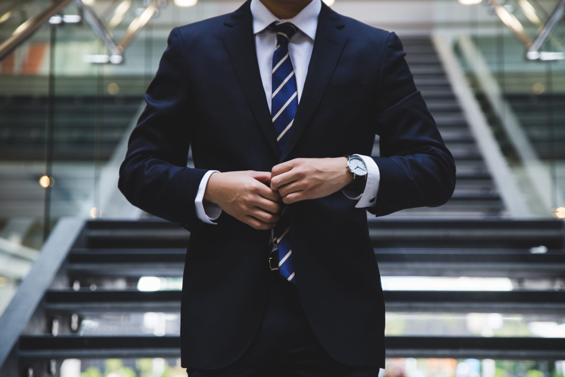 Smart man buttoning up his blazer